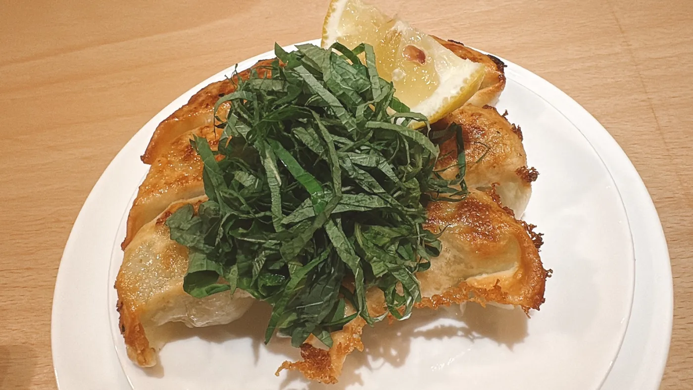 別邸 鶴亀堂の特製鶴亀しそ餃子。刻みしそがたっぷりのった大きめの餃子