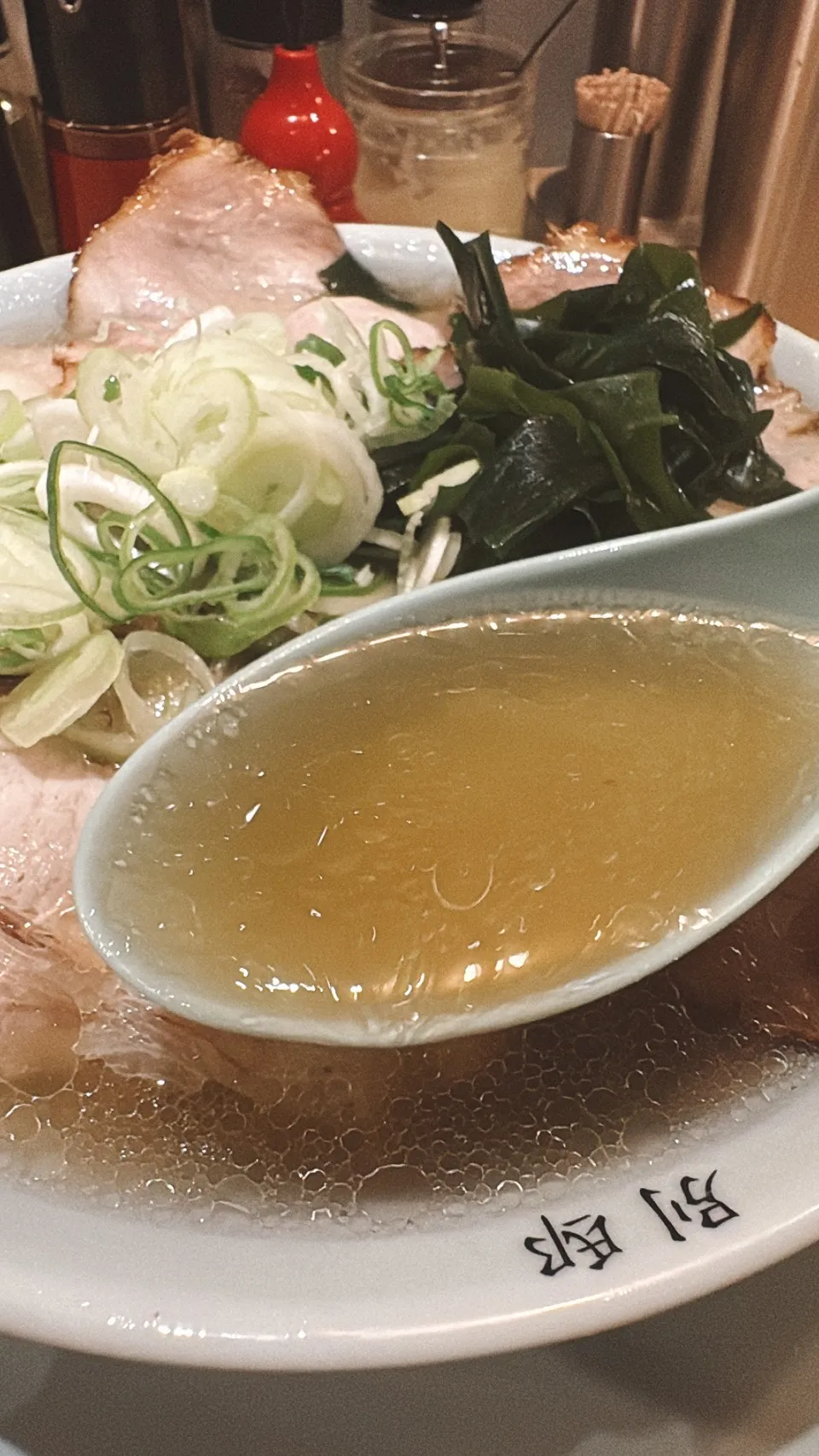 別邸 鶴亀堂の豚清湯のスープをレンゲですくったところ