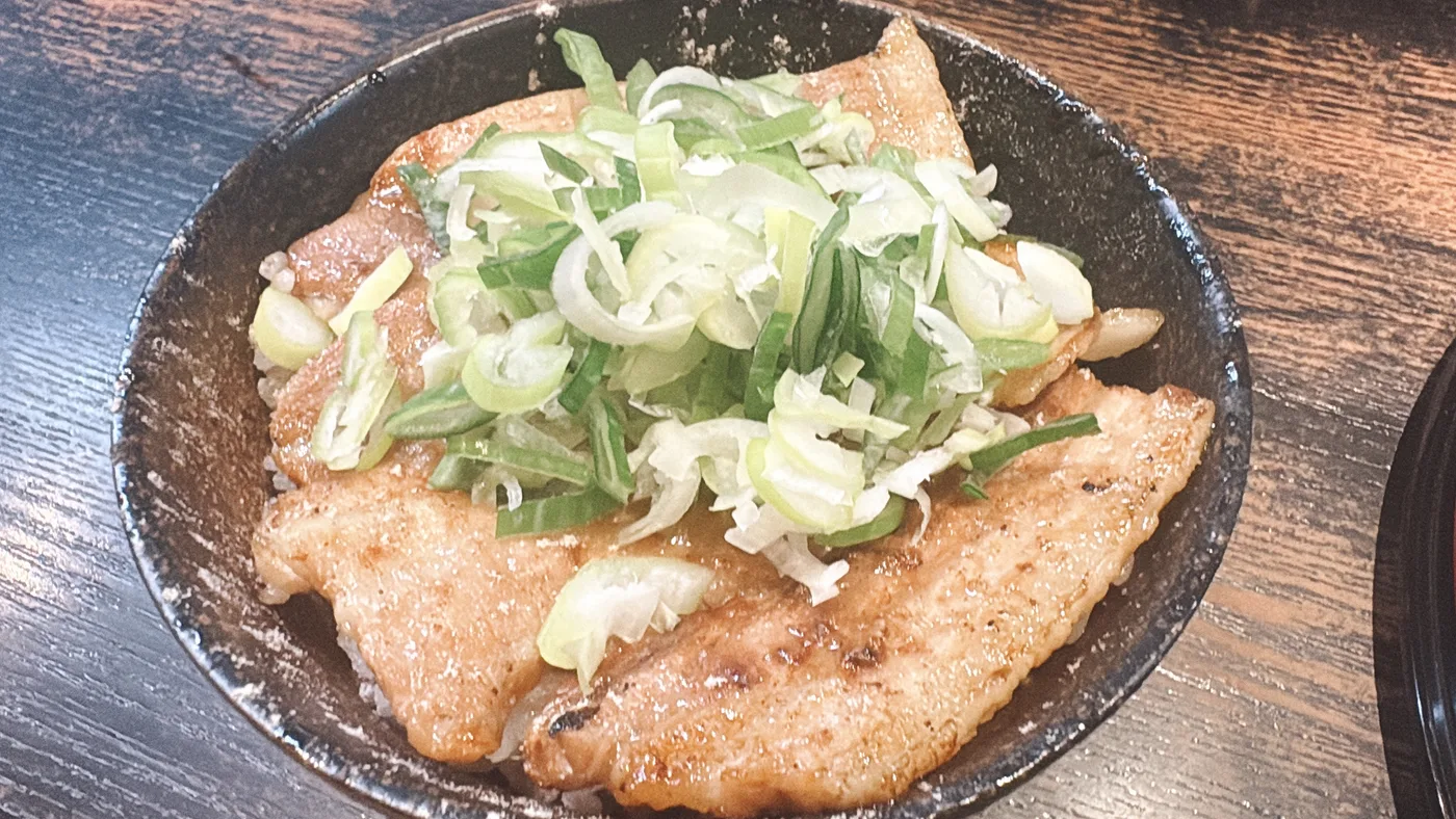 草津亭のランチセット豚丼カルビ。香ばしく焼かれた豚カルビにねぎと薬味がたっぷりのった一品