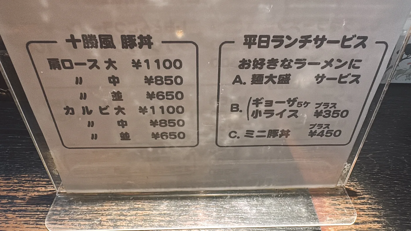 草津亭の十勝風豚丼メニューと平日ランチサービスの案内板