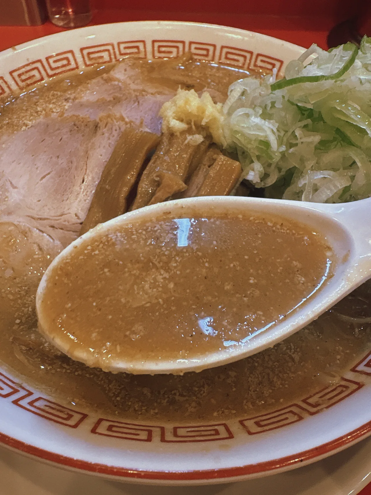 ラーメン荒畑 黒川店の味噌ラーメンのスープをレンゲですくったところ