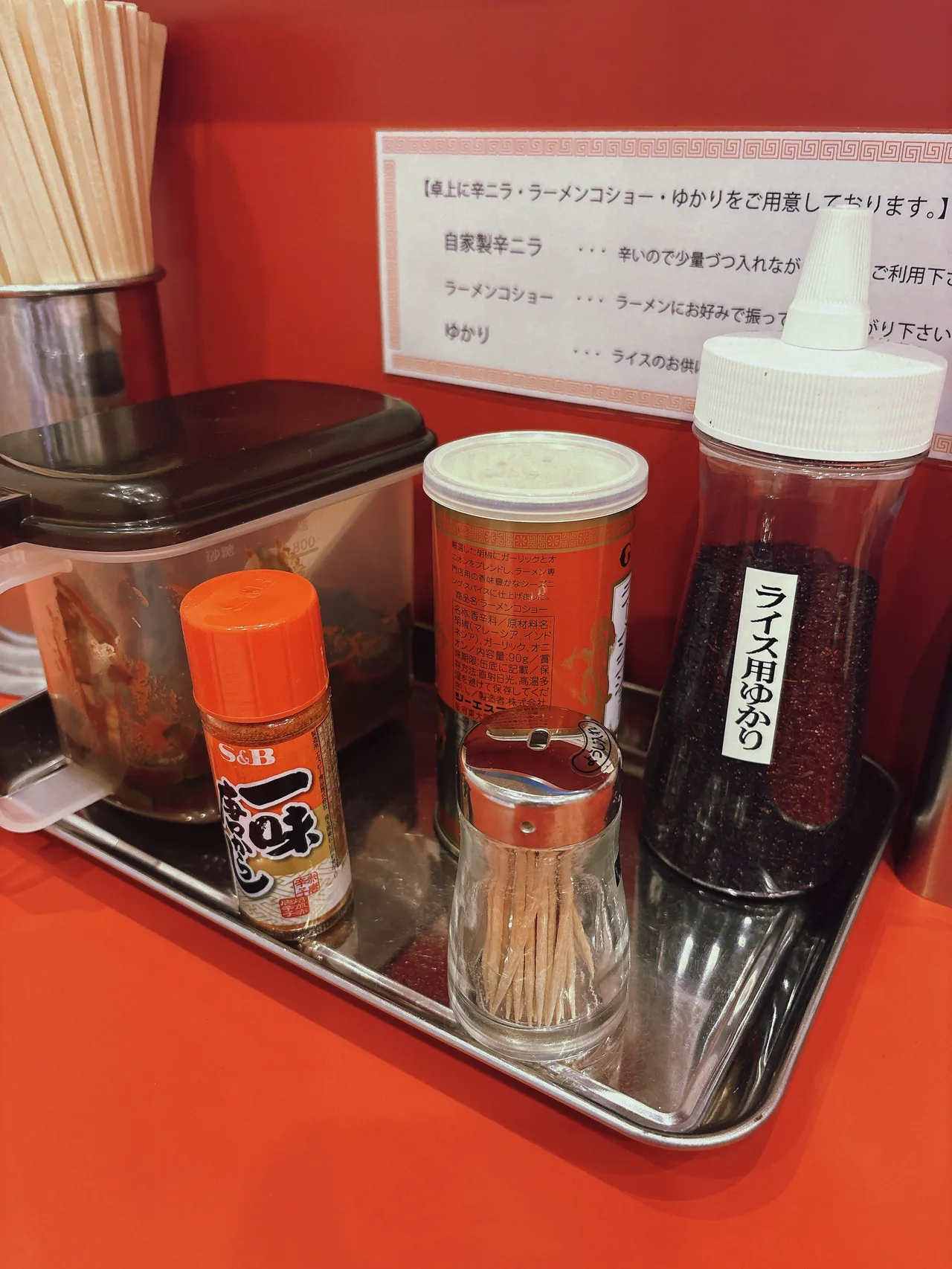 ラーメン荒畑 黒川店の卓上調味料。自家製辛ニラ、ラーメンコショー、ライス用ゆかりが並ぶ