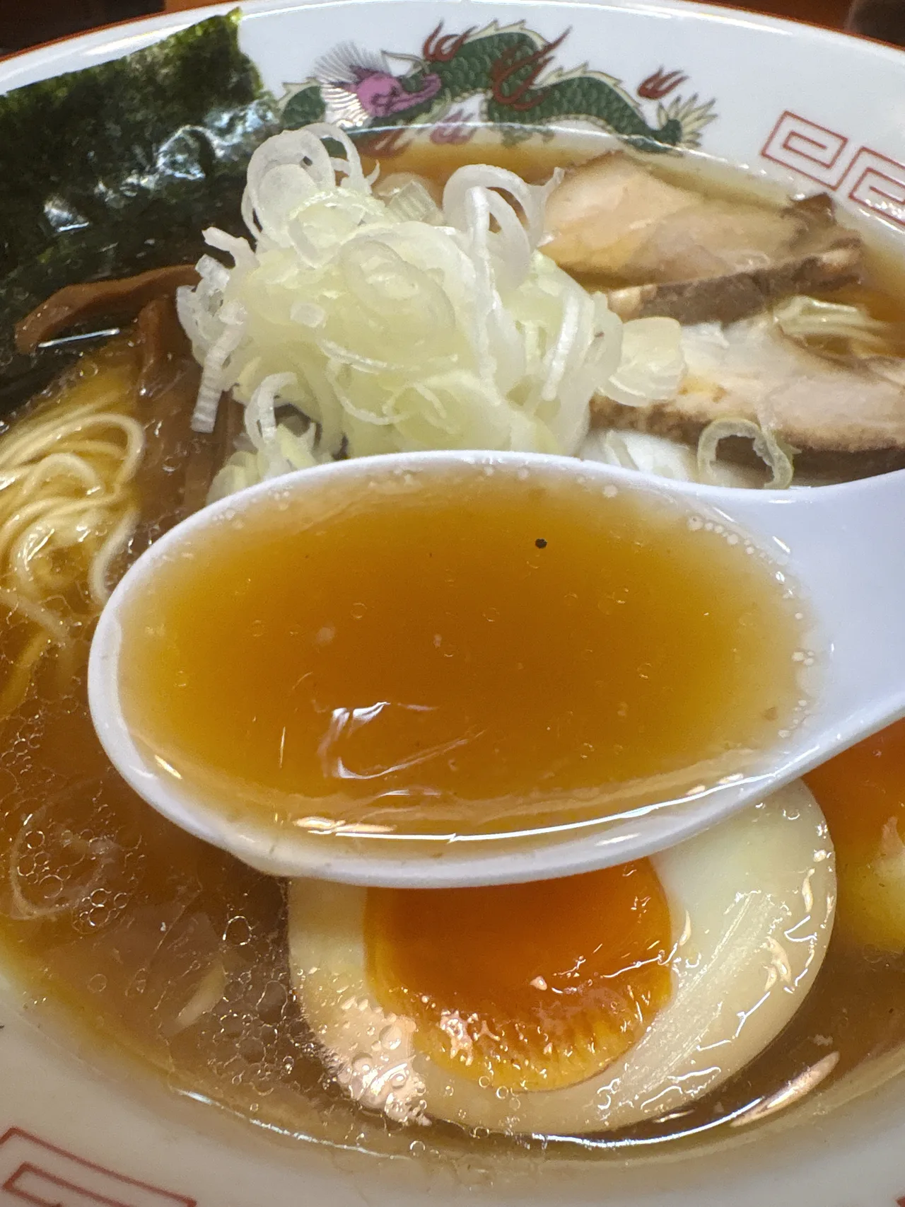 太陽食堂の味玉中華そばのスープをレンゲですくったところ