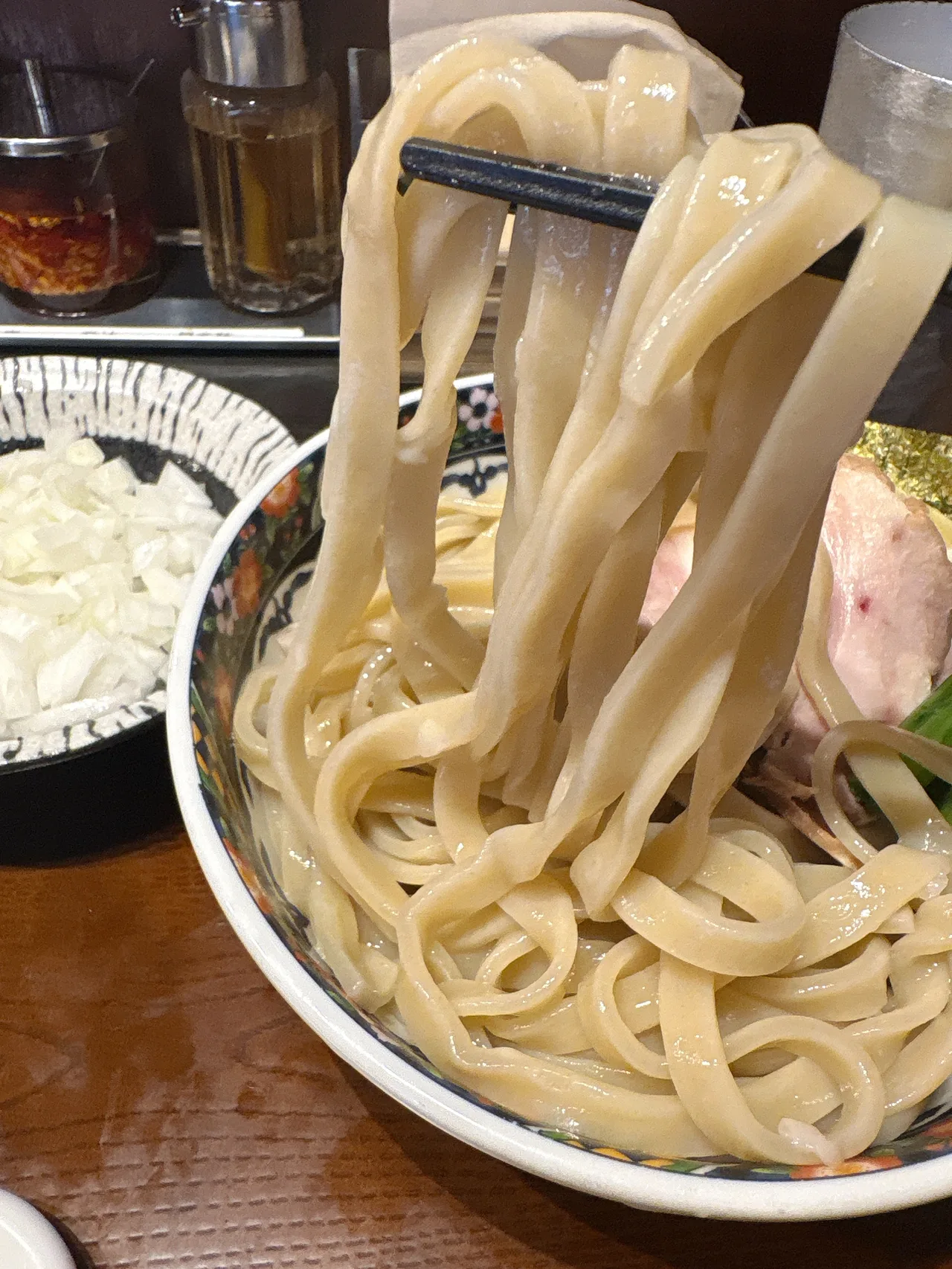 中華蕎麦 一番舎の赤海老つけ麺の麺をリフトしたところ。きしめんのような平打ち麺