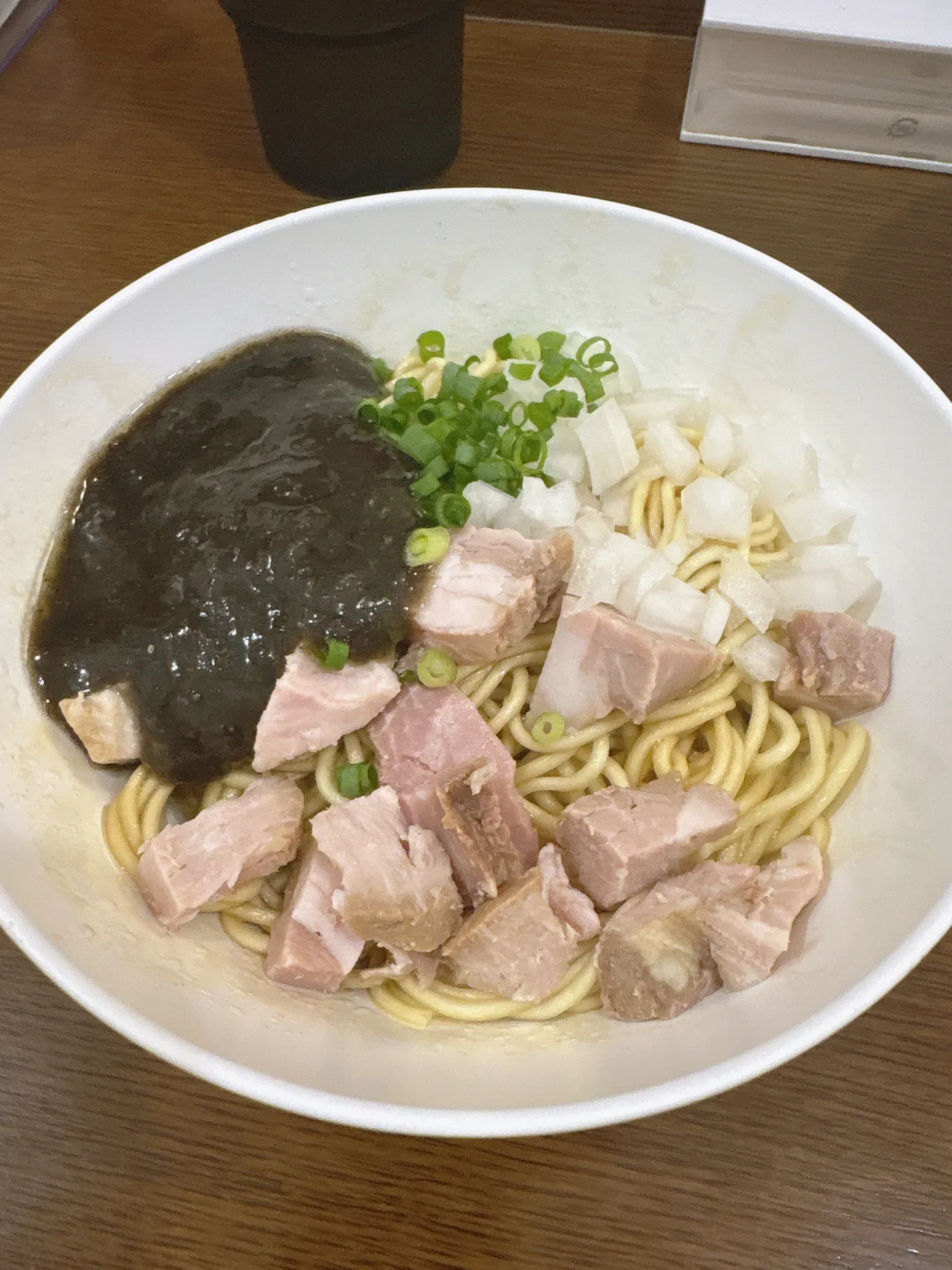 煮干し中華そば 魚魚の限定メニュー、イカペーニョの和え玉。黒いソースと刻み玉ねぎ、チャーシューがのった麺