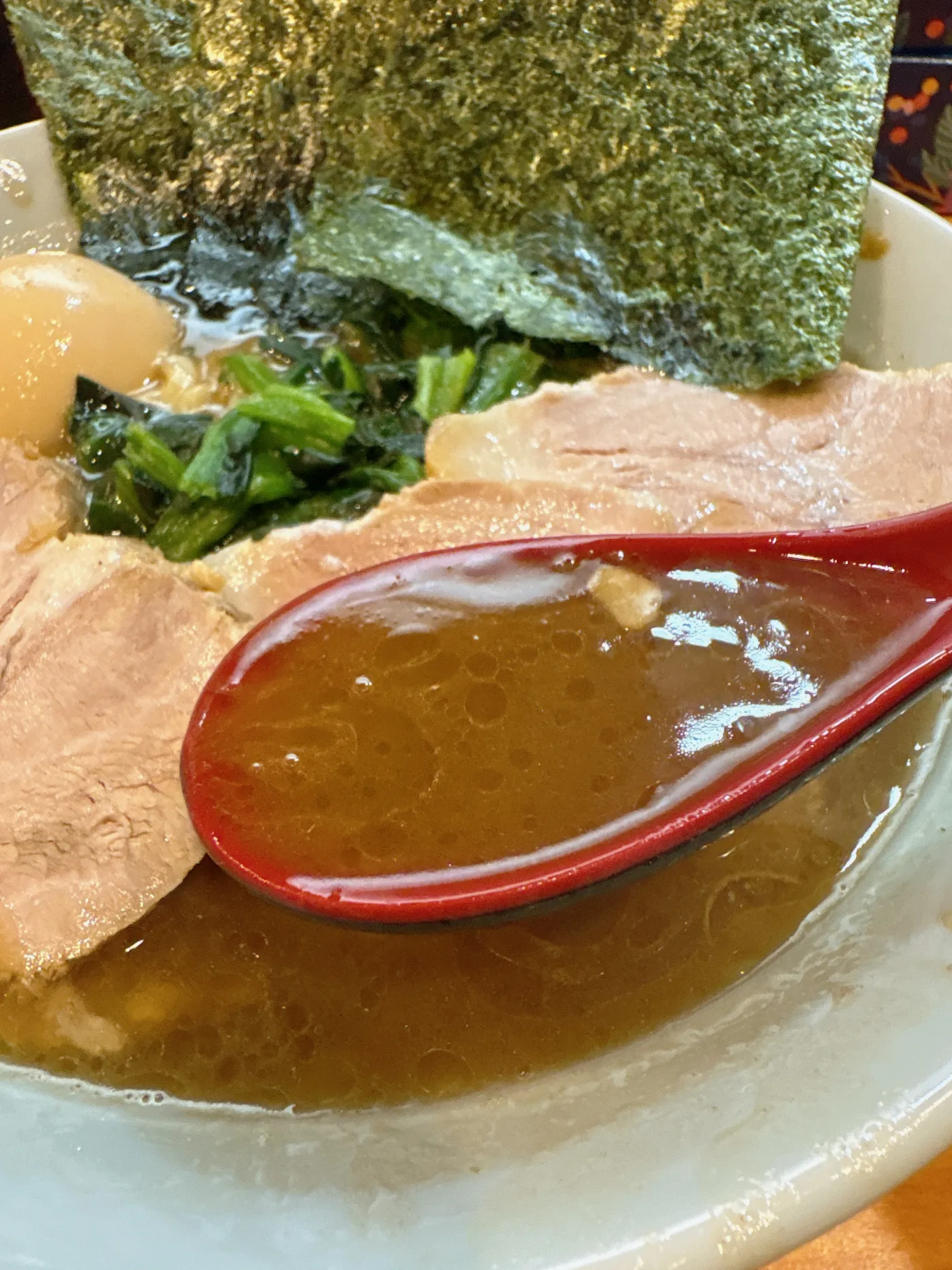 横浜家系らーめん 志のスープをレンゲですくったところ