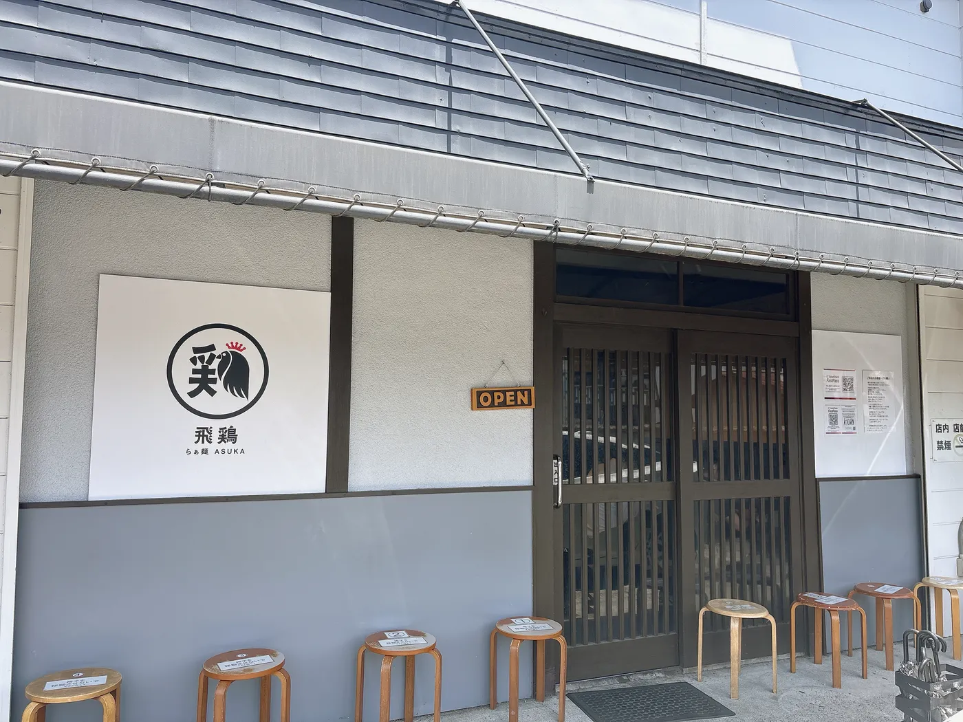 らぁ麺 飛鶏の店構え。「飛鶏 らぁ麺 ASUKA」の看板とOPENの札