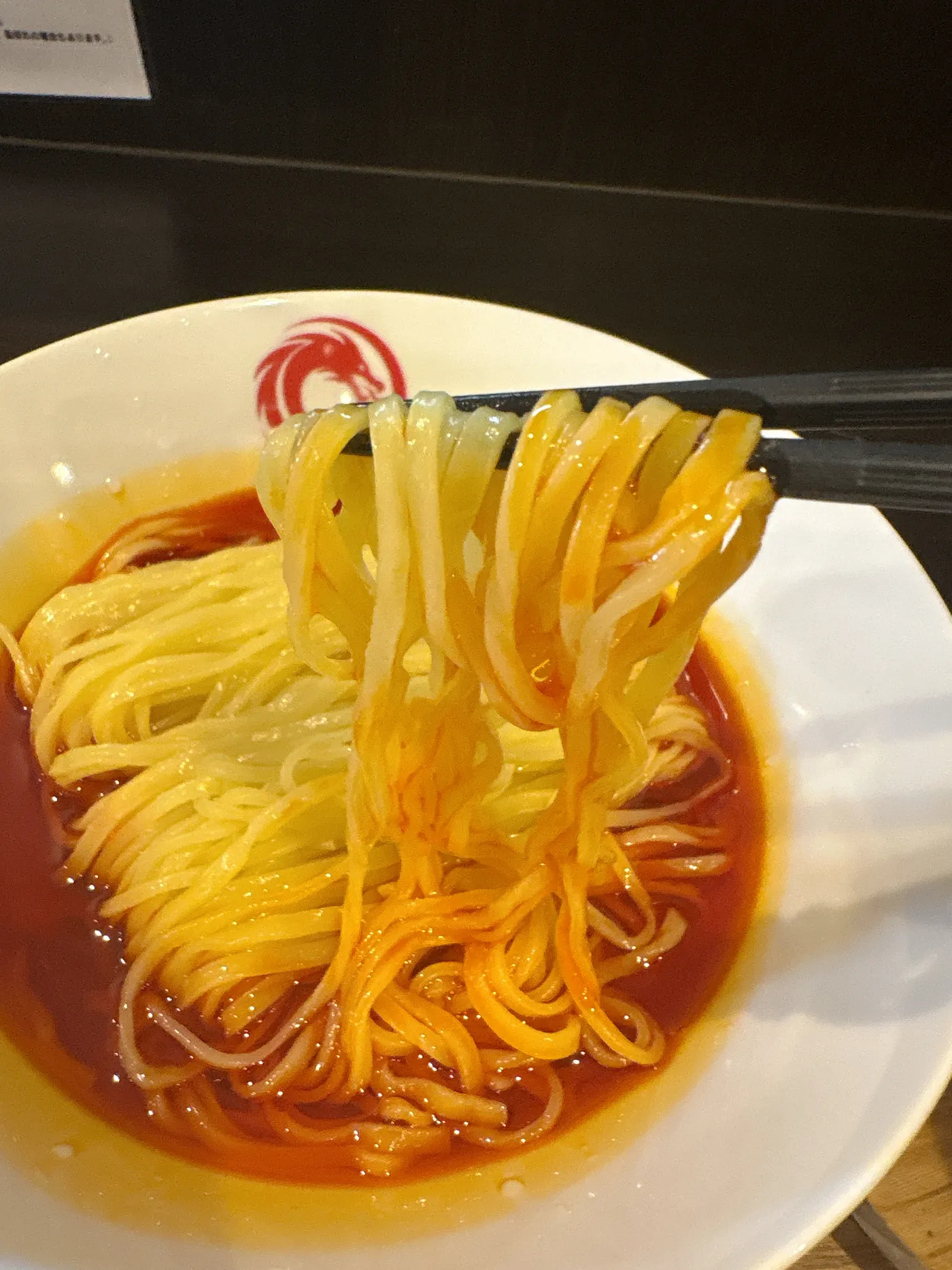 担々麺 威風堂々の麺をリフトしたところ。細めの真っ赤なストレート麺