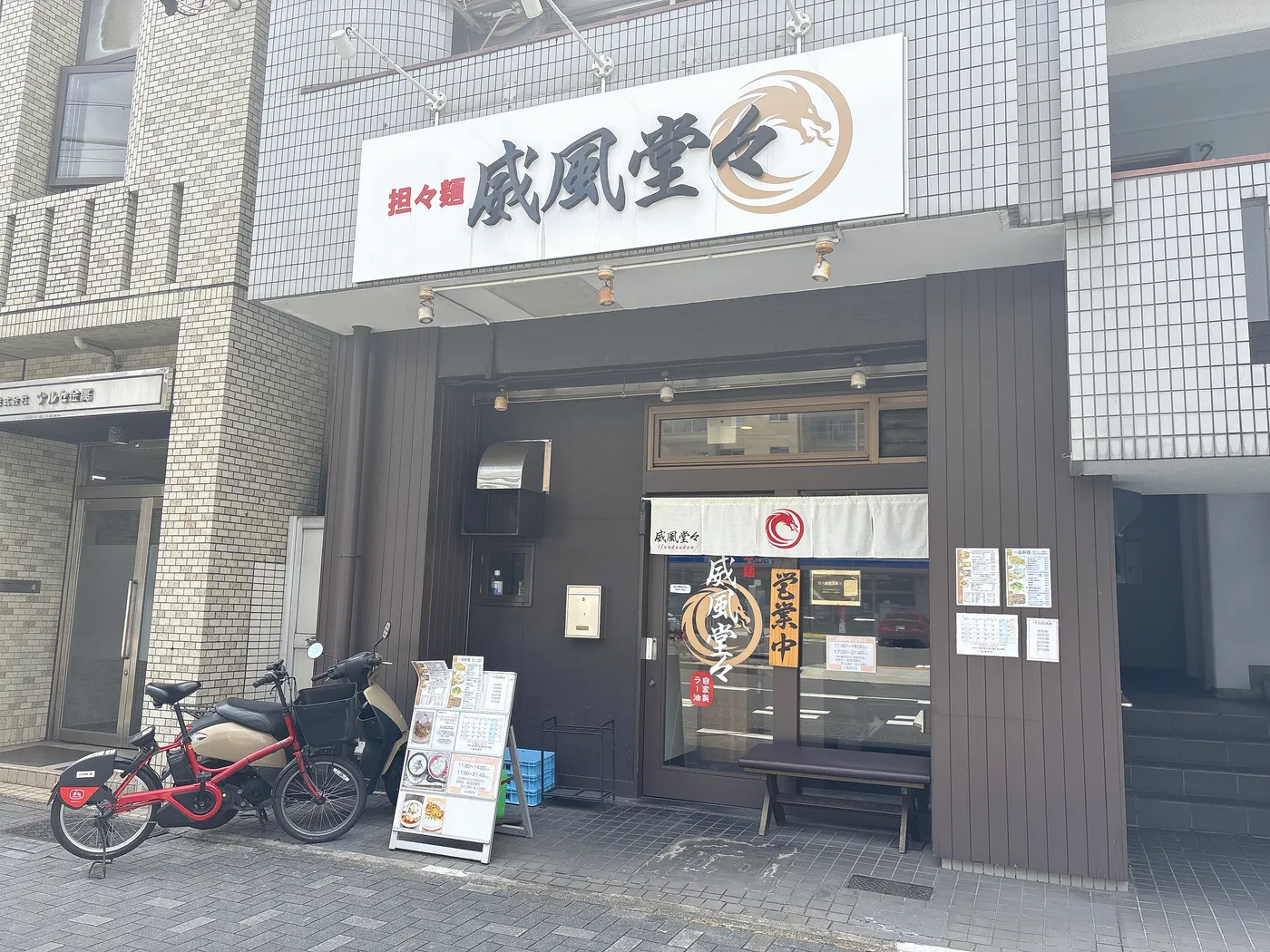担々麺 威風堂々の店構え。「担々麺 威風堂々」の看板と赤い龍のロゴ
