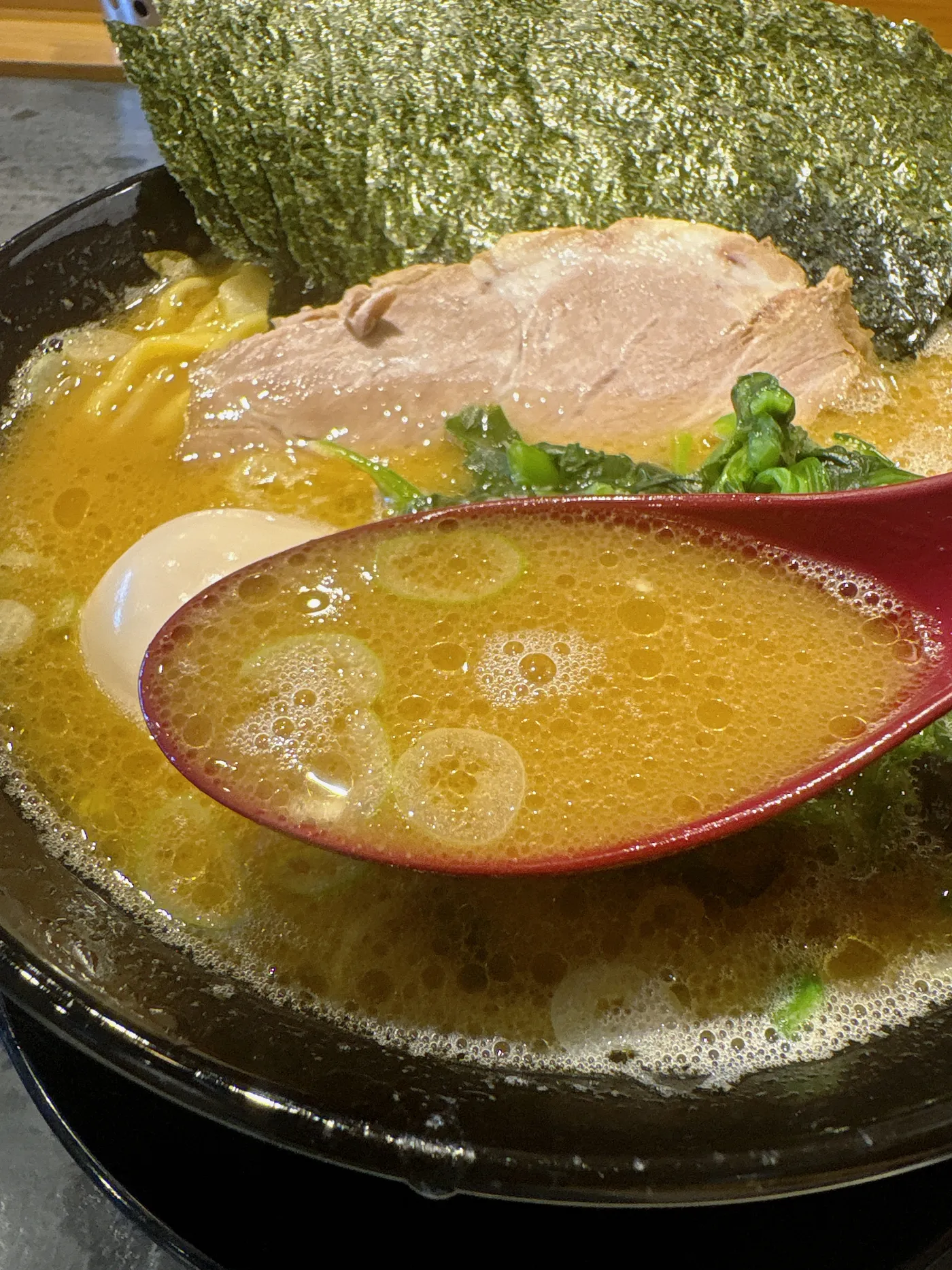 家系ラーメン桜家のスープをレンゲですくったところ