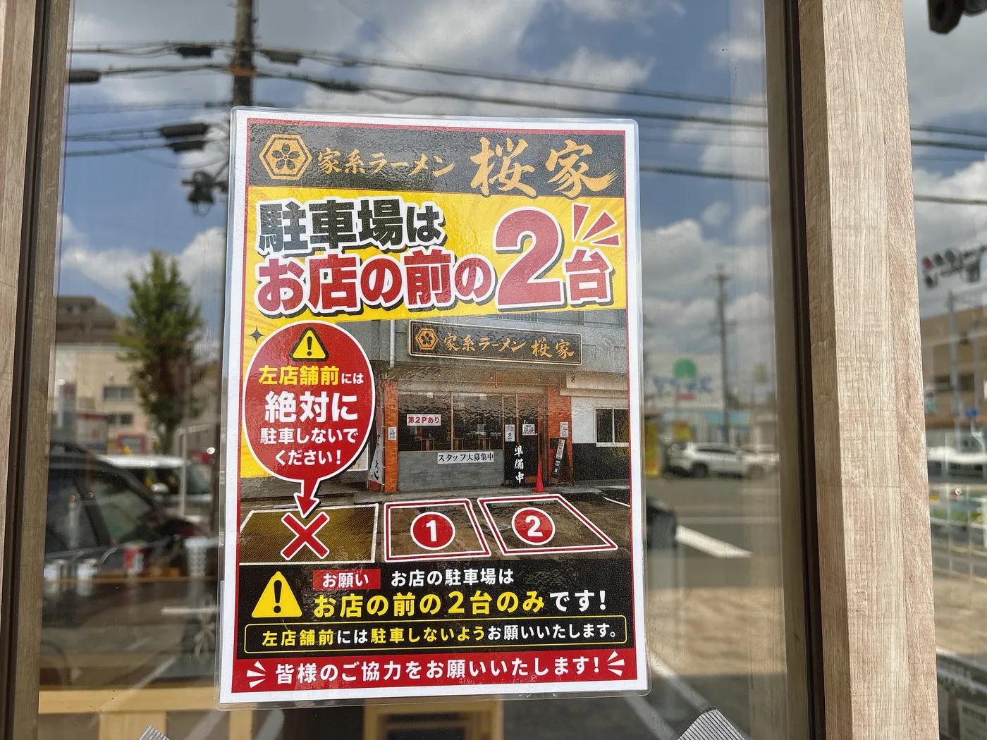 家系ラーメン桜家の駐車場案内。お店の前の2台のみで、隣の店舗前には駐車しないよう案内がある