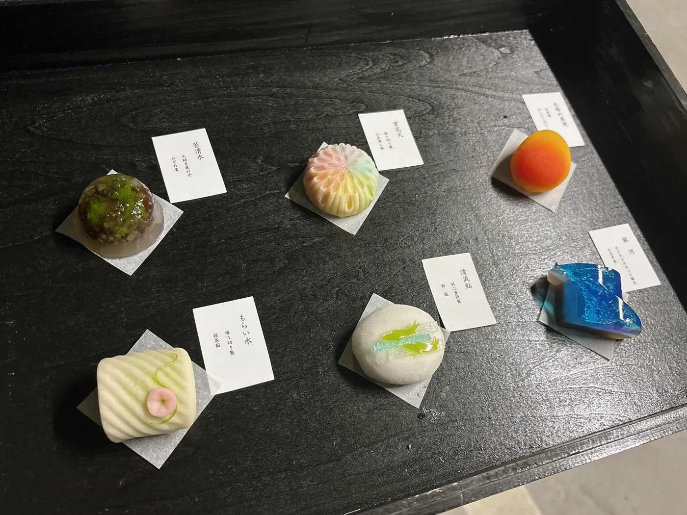 和の菓 さんのうの季節の上生菓子6個入。黒い盆に銘の紙が添えられた6つの上生菓子が並ぶ