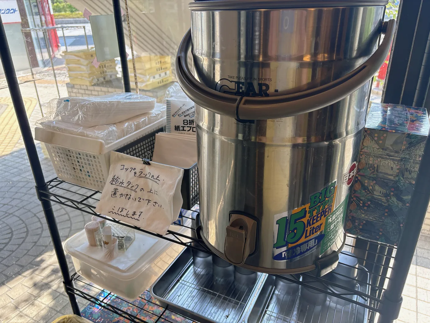 ラーメン つづきのセルフ給水タンクと紙エプロン、髪留め