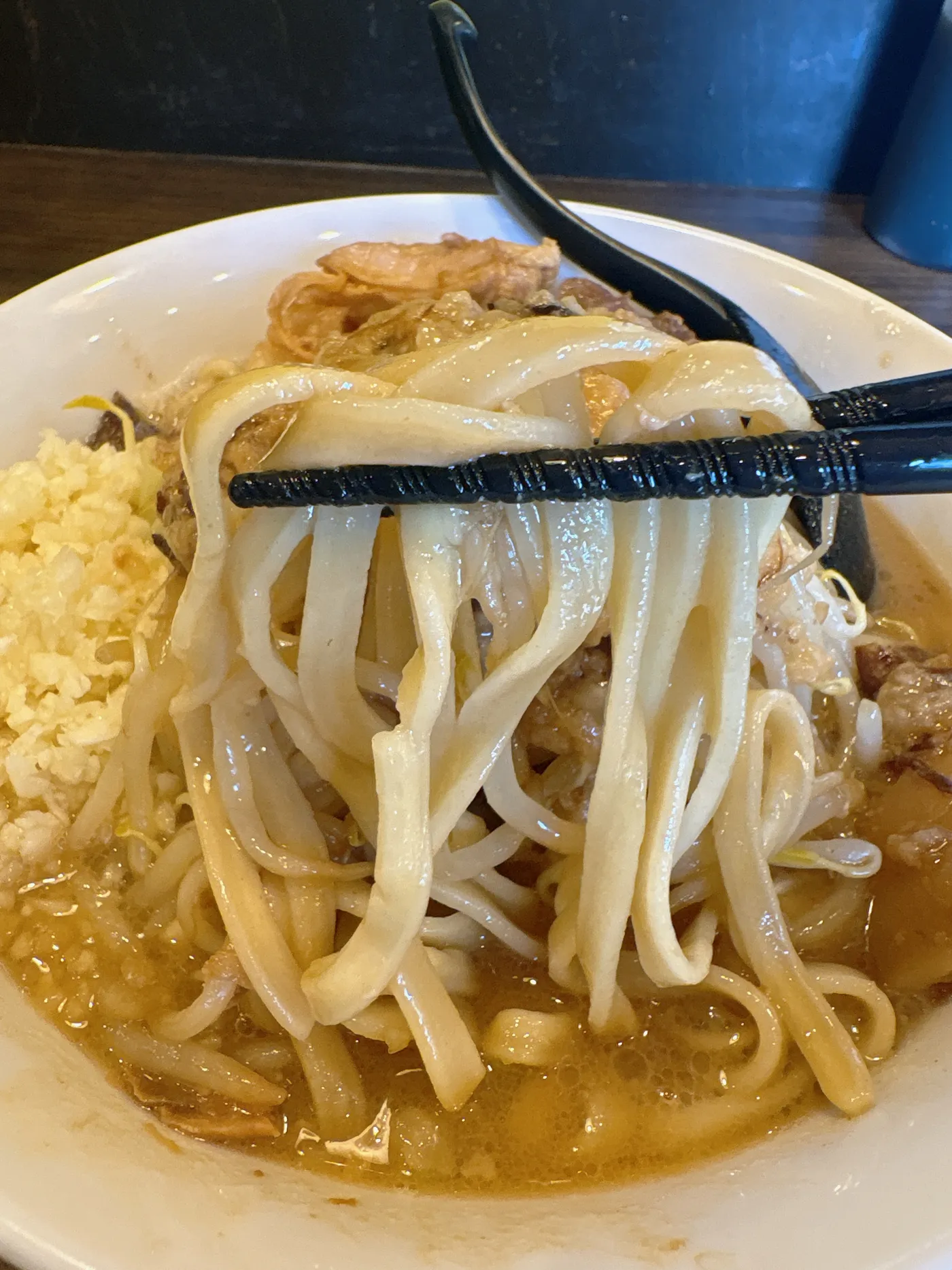ラーメン つづきの麺をリフトしたところ。平打ちの太麺