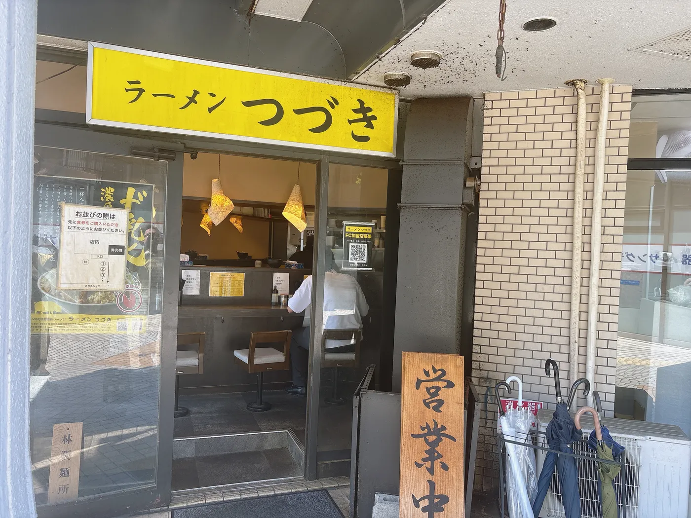 ラーメン つづきの店構え。黄色い「ラーメン つづき」の看板とカウンター席