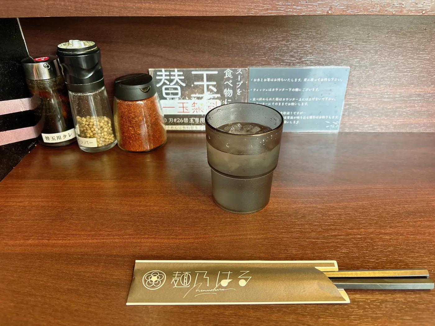 麺乃はるの卓上調味料。替玉用タレ、ホワイトペッパー、一味唐辛子が並ぶ