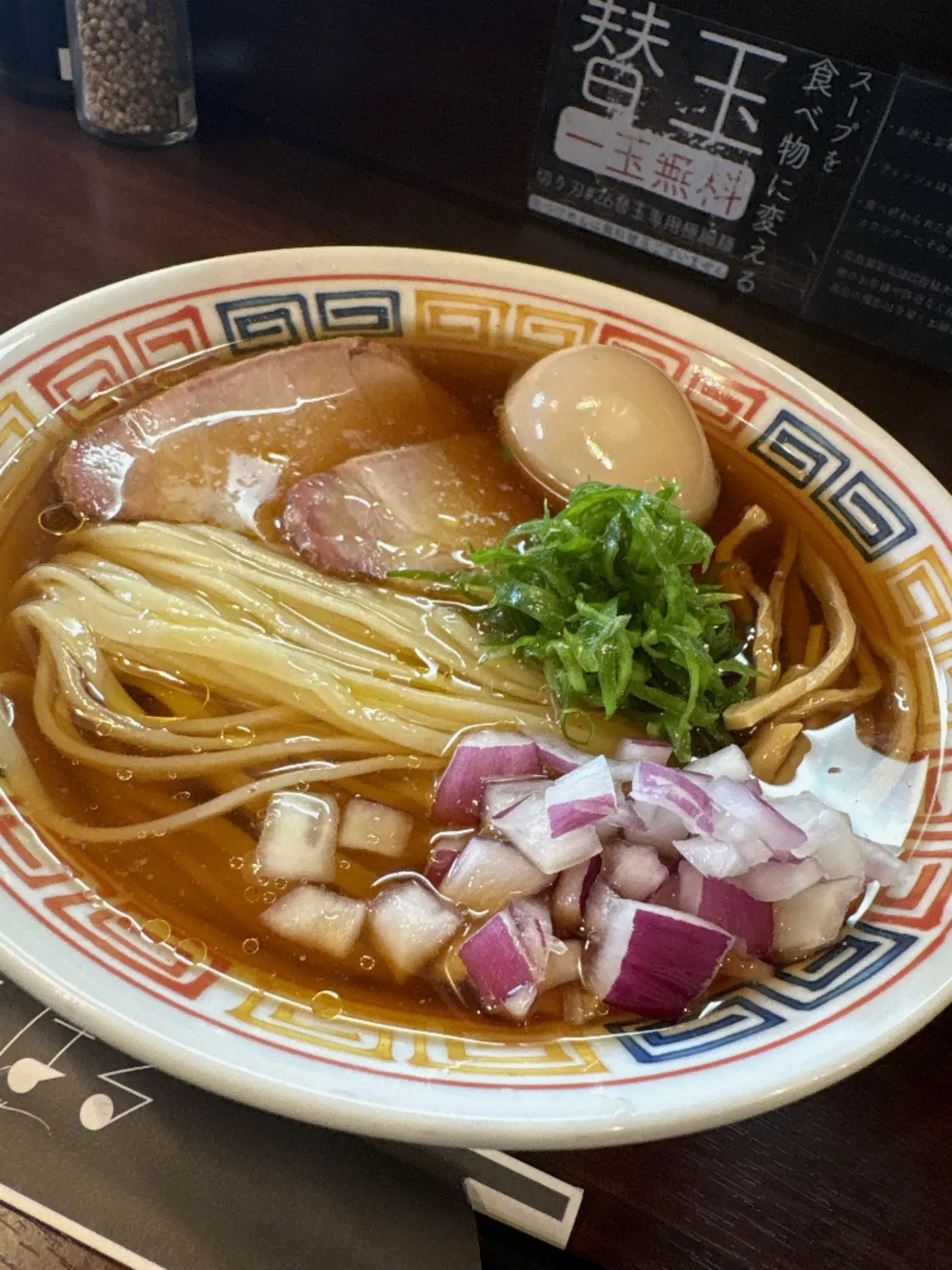 麺乃はるの冷たい醤油そばを別アングルから。奥に替玉一玉無料の案内板が見える