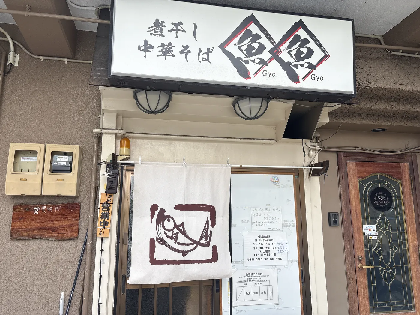 煮干し中華そば 魚魚の店構え。「煮干し中華そば 魚魚」の看板とのれん