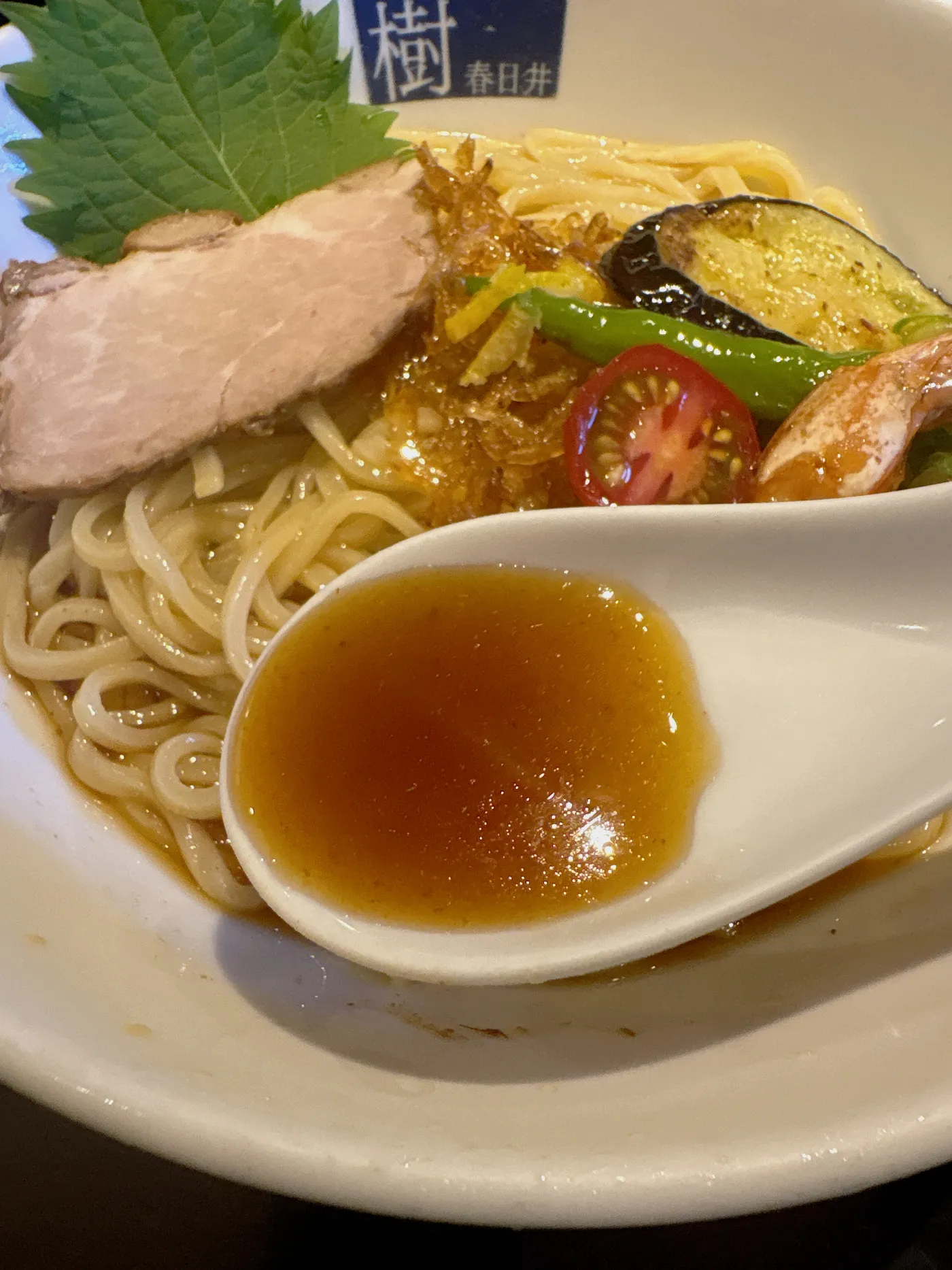 中華そば はる樹の柚子香るえび冷やし麺のスープをレンゲですくったところ