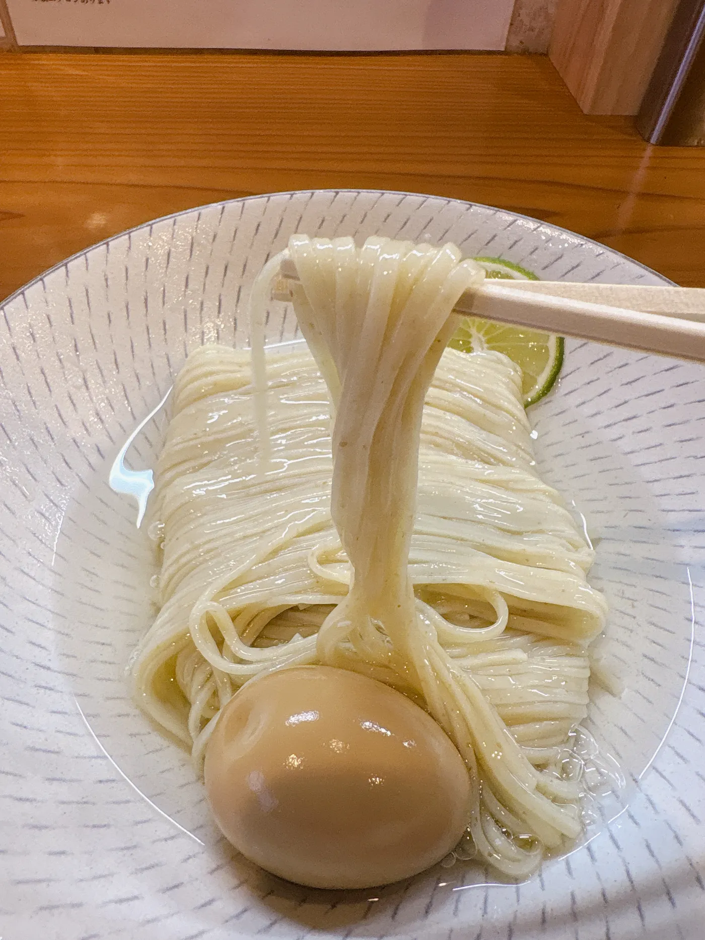 つけそば神宮寺の麺を箸でリフトしたところ。すだちが添えられている