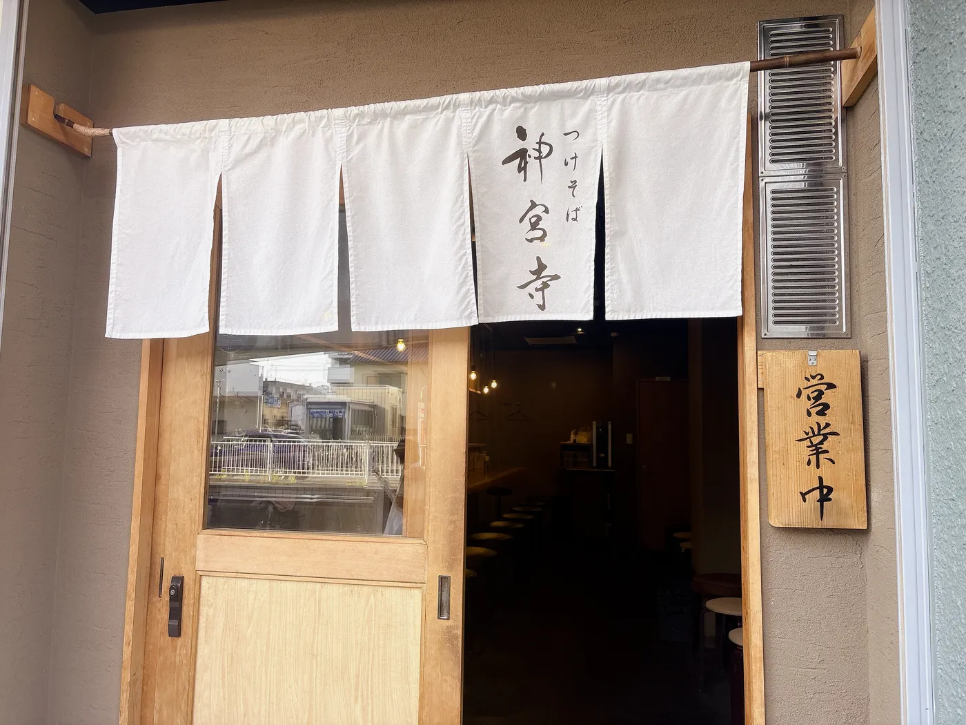 つけそば神宮寺の店構え。白いのれんに店名が入ったシンプルな入口