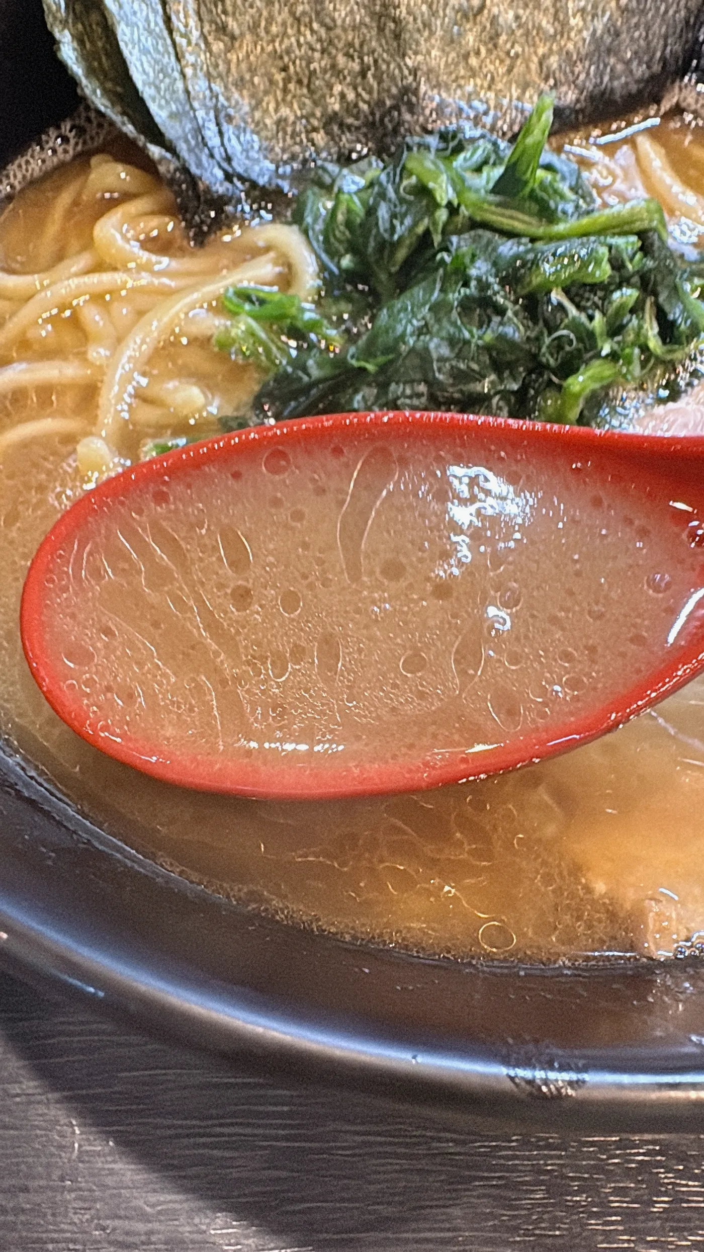横浜家系ラーメン 侍のスープをレンゲですくったところ