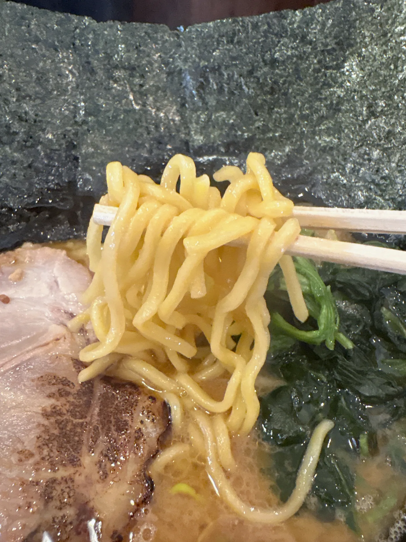 銀十の麺を箸で持ち上げたところ。短めの中太ストレート麺
