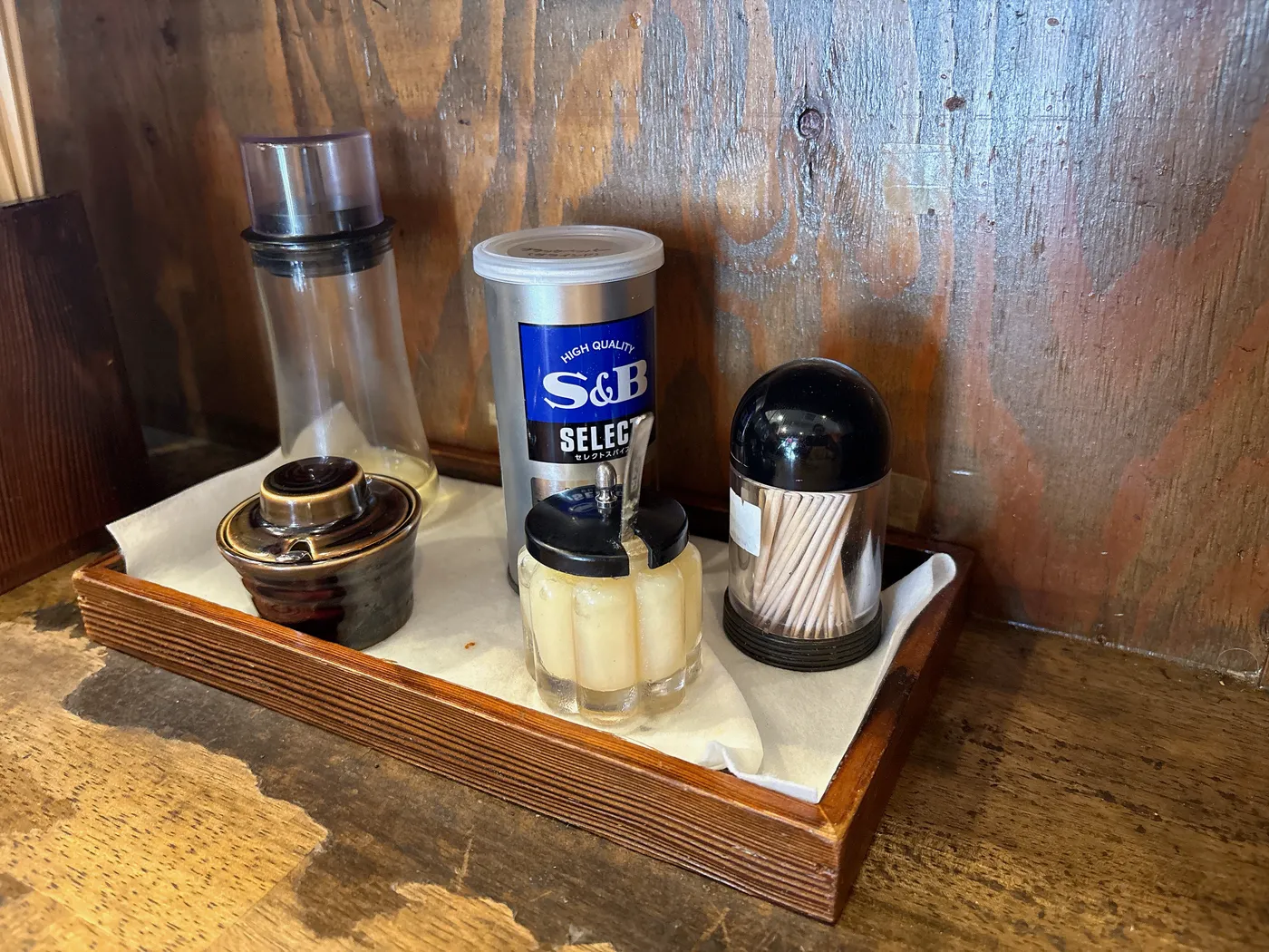 銀十の卓上調味料。S&Bの胡椒とにんにくが木のトレイに並ぶ