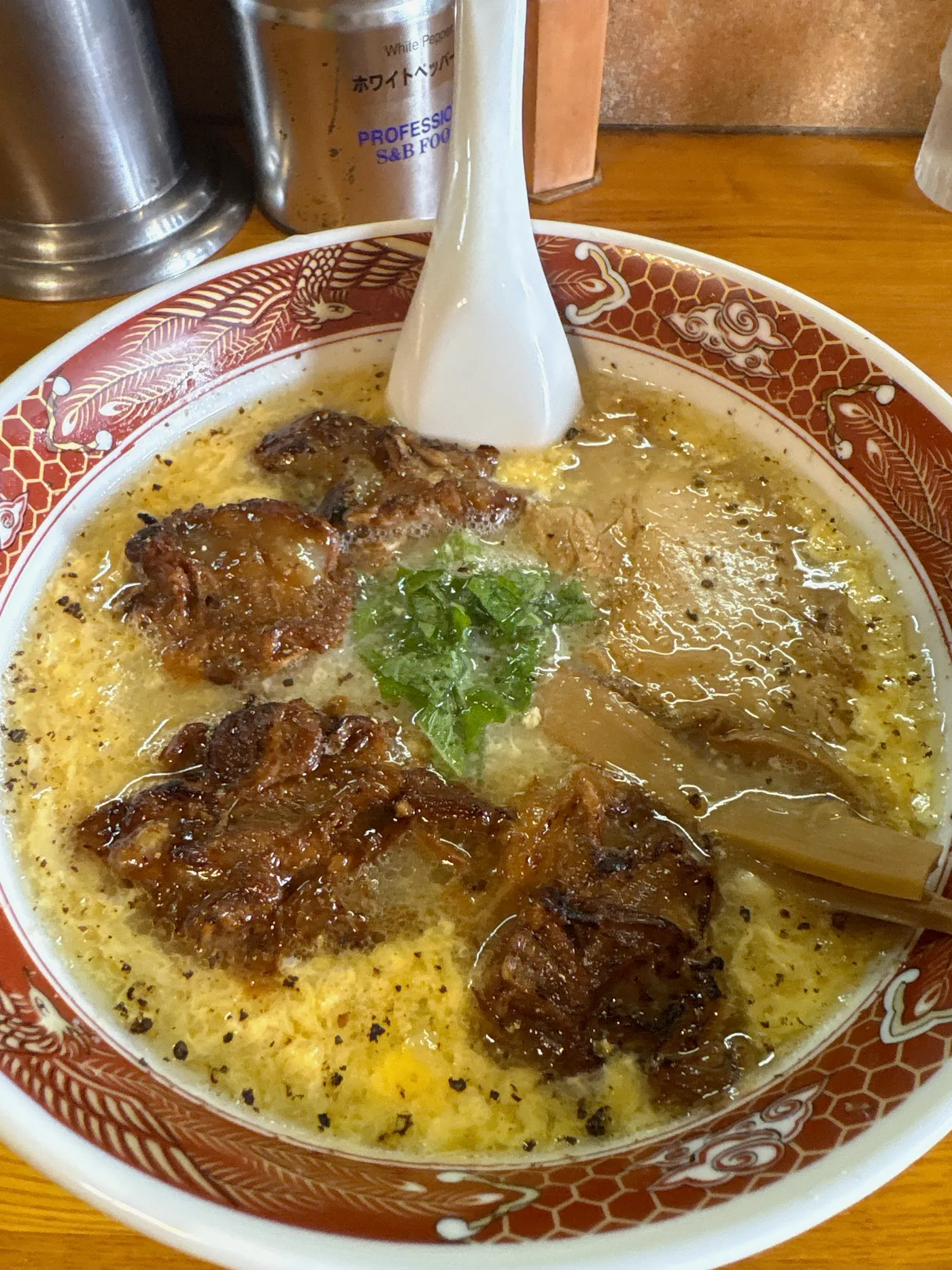 塩くもたま軟骨チャーシュー麺を真上から。ふわりと卵がとじられたスープの中央に大葉、まわりに軟骨チャーシューが3つ