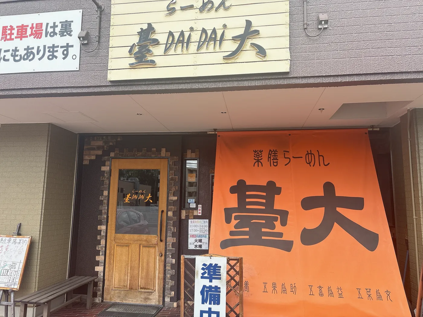 らーめん臺大の店構え。「らーめん 臺 DAI DAI 大」の看板とオレンジの「薬膳らーめん 臺大」の幕