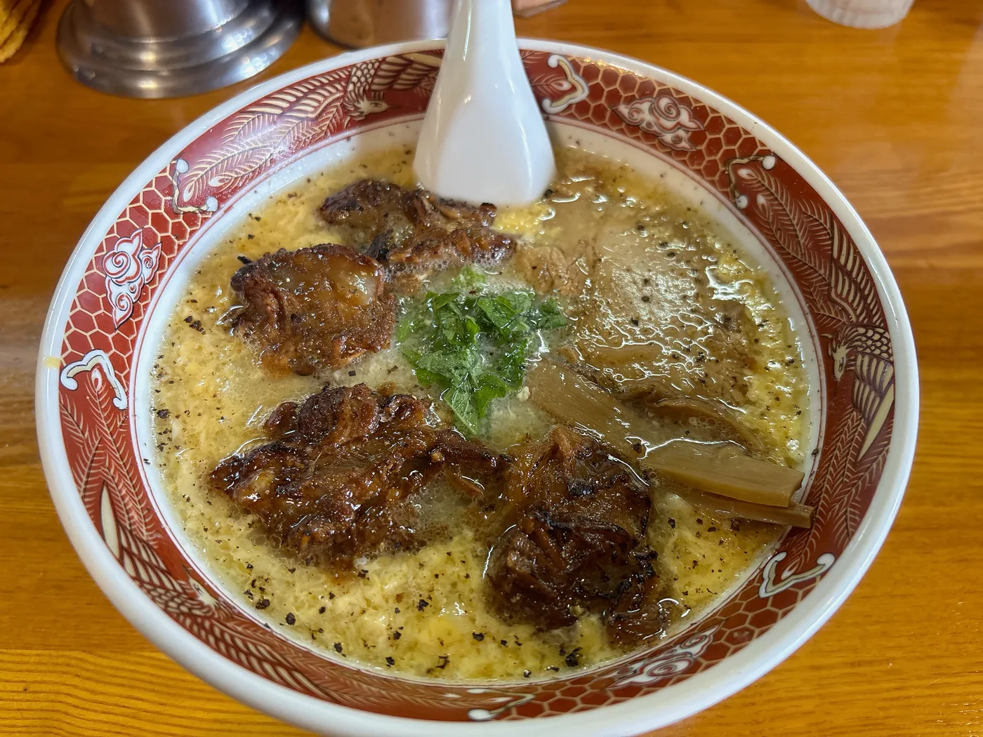 らーめん臺大の塩くもたま軟骨チャーシュー麺。卵でとじた白いスープに軟骨チャーシューと大葉、メンマがのる